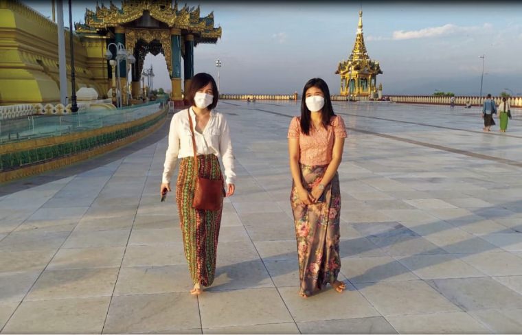 朝日新聞ヤンゴン支局秘書のチョーケイカインモウさん（右）と共に仏塔を訪れた福山亜希記者