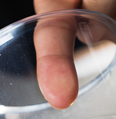 透明なプラスチックコップの内側に、指の先をベタッとくっつける。